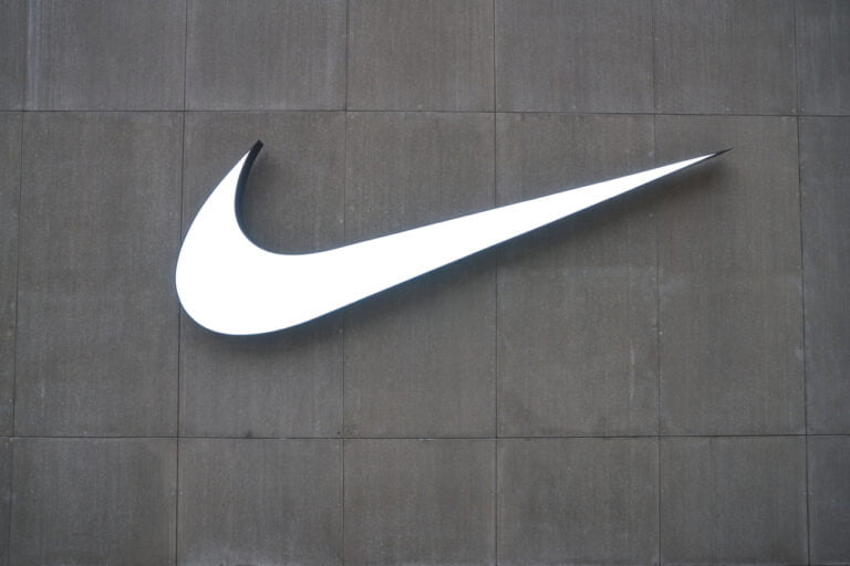 logo spolecnosti nike a pozadi je sedo cerna barva
