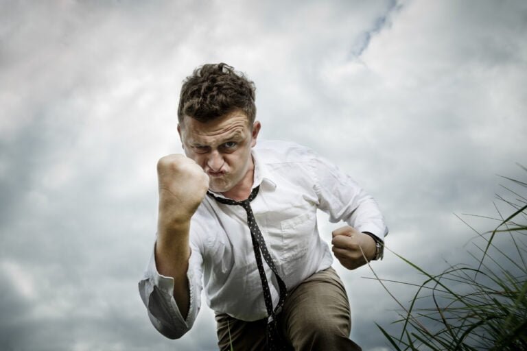 Mladý muž ukazuje pěst. Je silný a odhodlaný bojovat, koncept nevzdat se a pokračovat dál