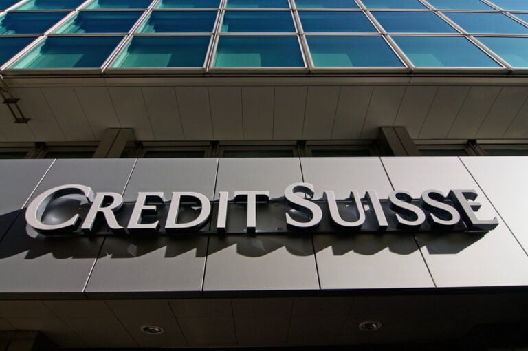Nápis Credit Suisse Bank visí před budovou v Luganu. Credit Suisse je globální investiční banka a společnost poskytující finanční služby v oblasti správy majetku.