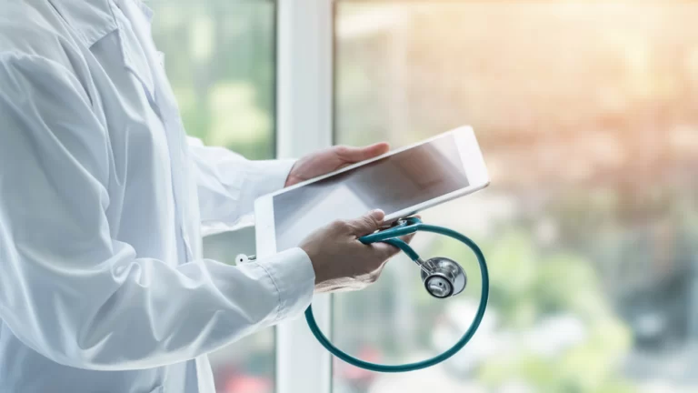 Lékař drží v rukou iPad, platforma Doximity