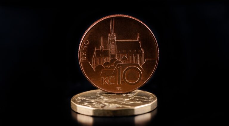 České mince v nominálních hodnotách 10 a 20 korun na černém pozadí