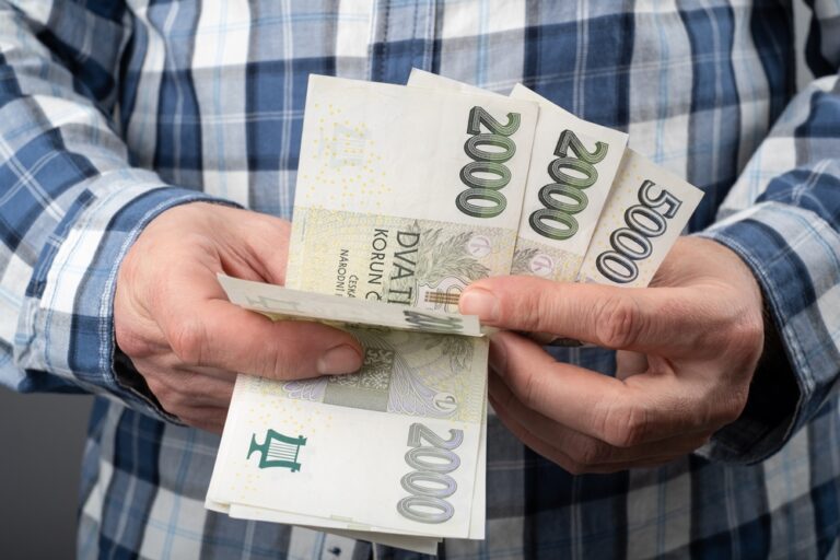 Muž v košili drží v ruce bankovky o hodnotě 2000 Kč. Koncep: Průměrná mzda v Česku se zvýšila