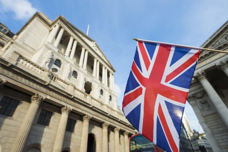 Britská vlajka vlající před Bank of England v londýnském finančním centru