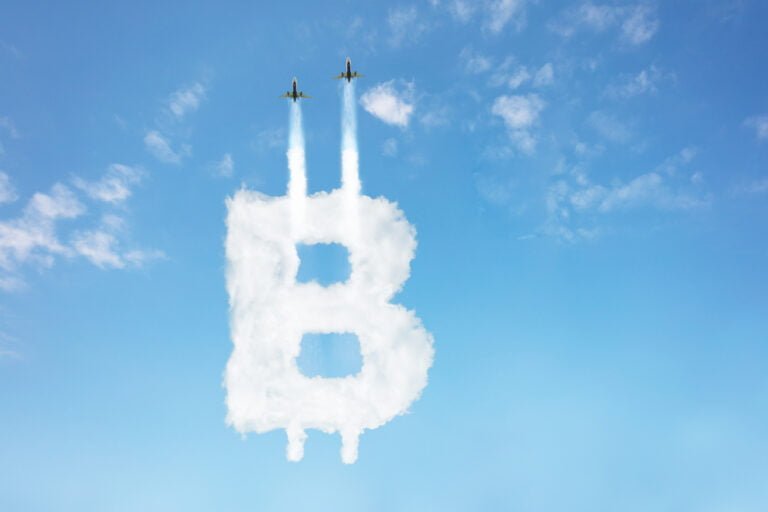 Tryskové letadlo a symbol Bitcoinu v oblacích, koncept jeho růstu