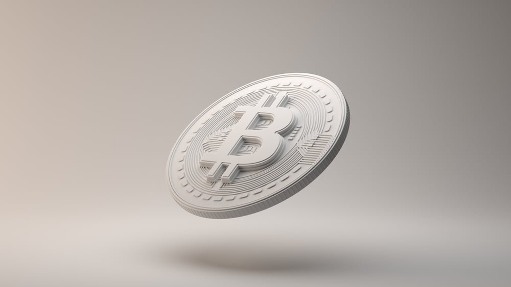 Na bílém pozadí je mince Bitcoinu, koncept hodnota Bitcoinu a jeho cenová stabilita