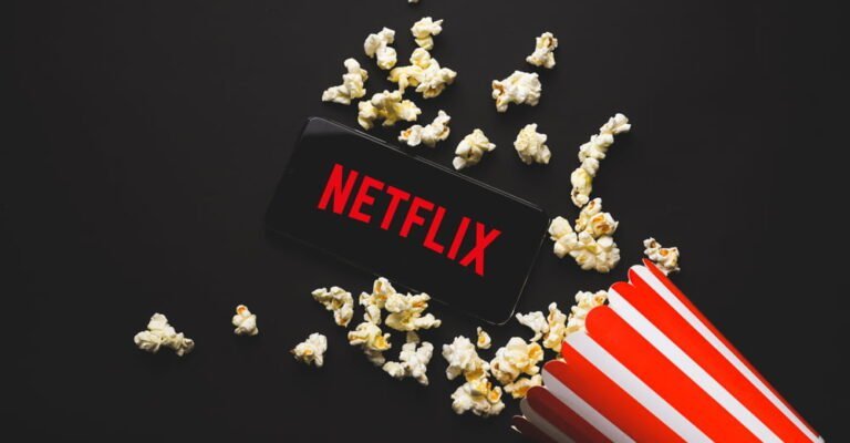 Telefon s obrazovkou Netflix, rozsypaný popcorn